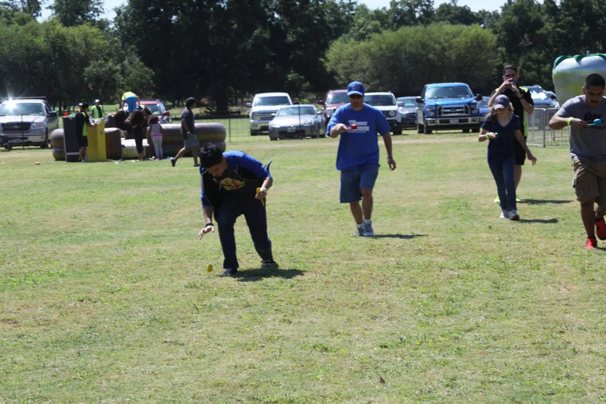 Classic corporate Family Day picnic game - egg-on-a-spoon race staged at a Dallas Fort Worth company lawn